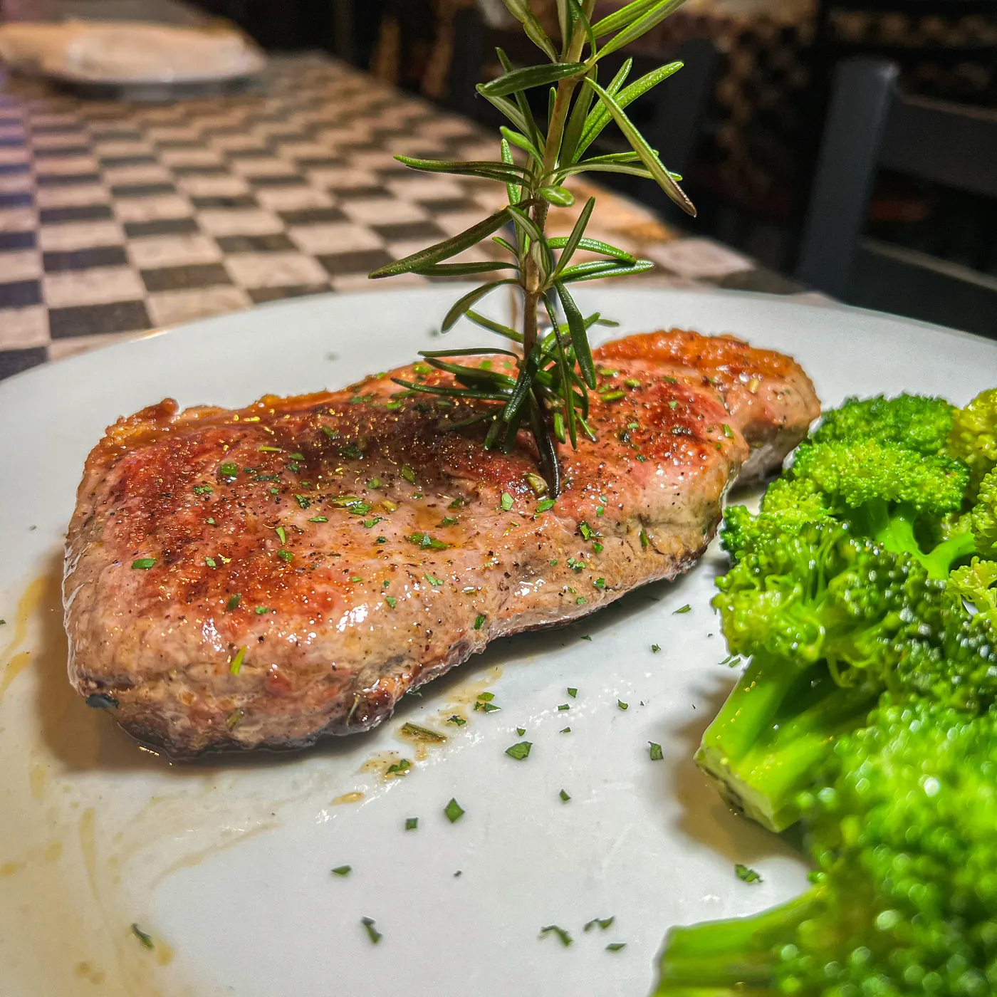 A New York strip steak with broccoli and rosemary
