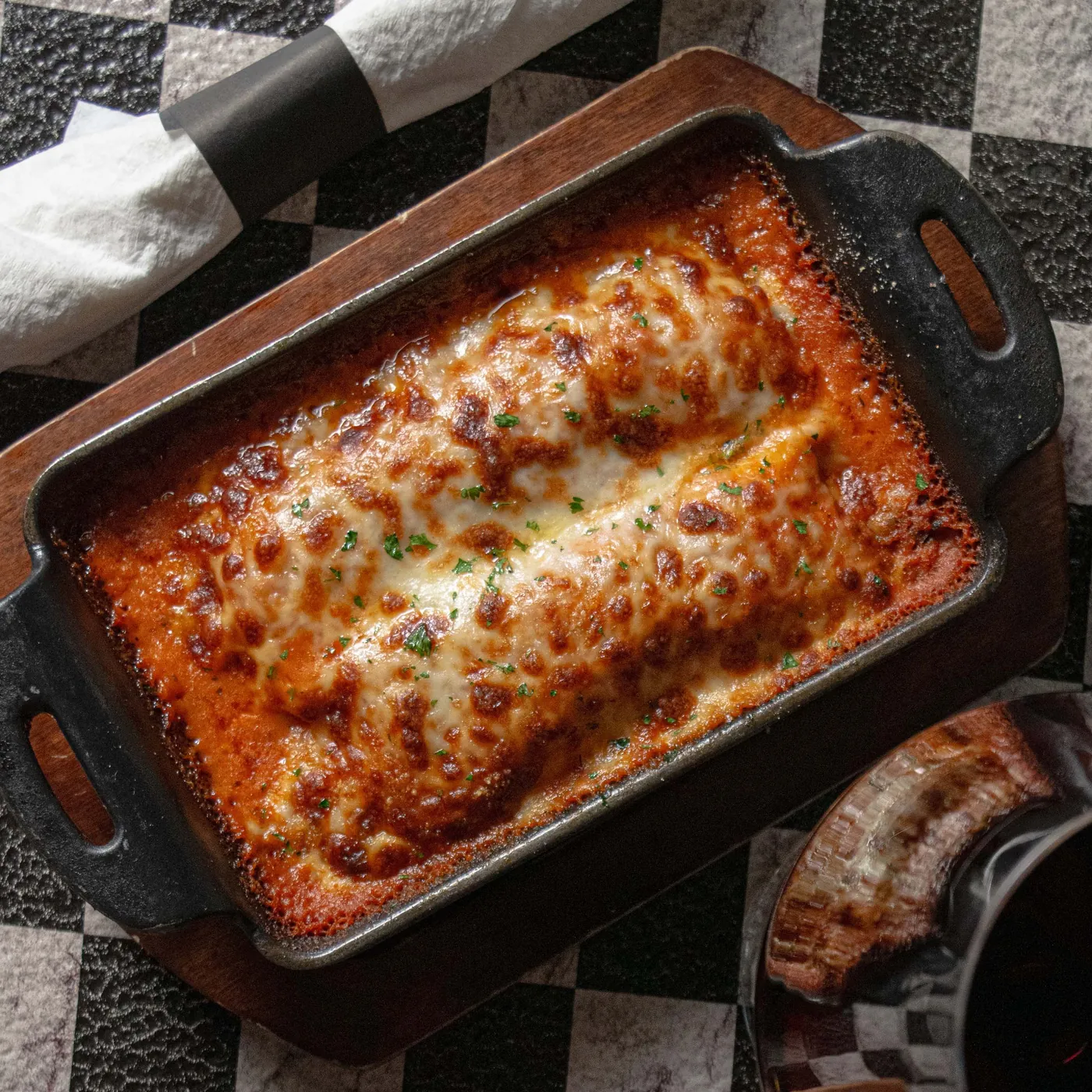 Baked cannelloni in a cast pan under melted cheese