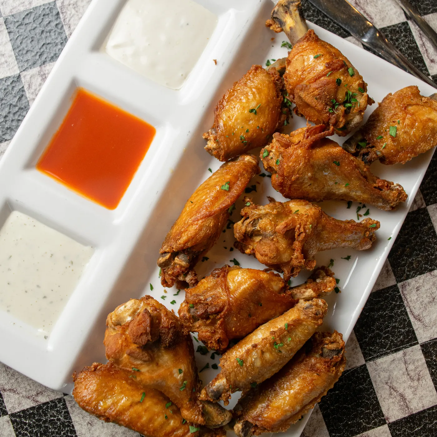 Fried chicken wings on a tray with three dipping sauces